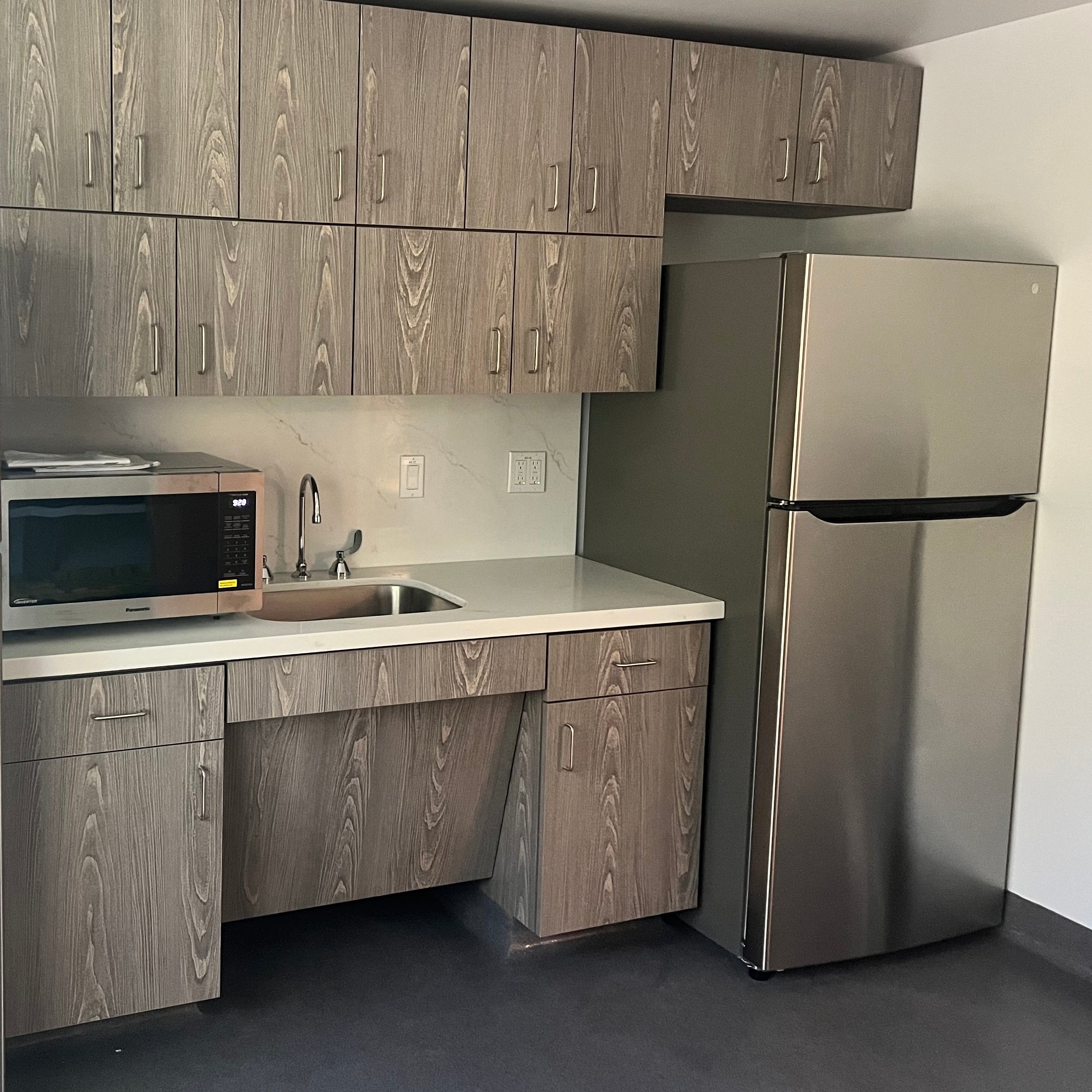 Modern kitchen with stainless steel appliances and wooden cabinets.